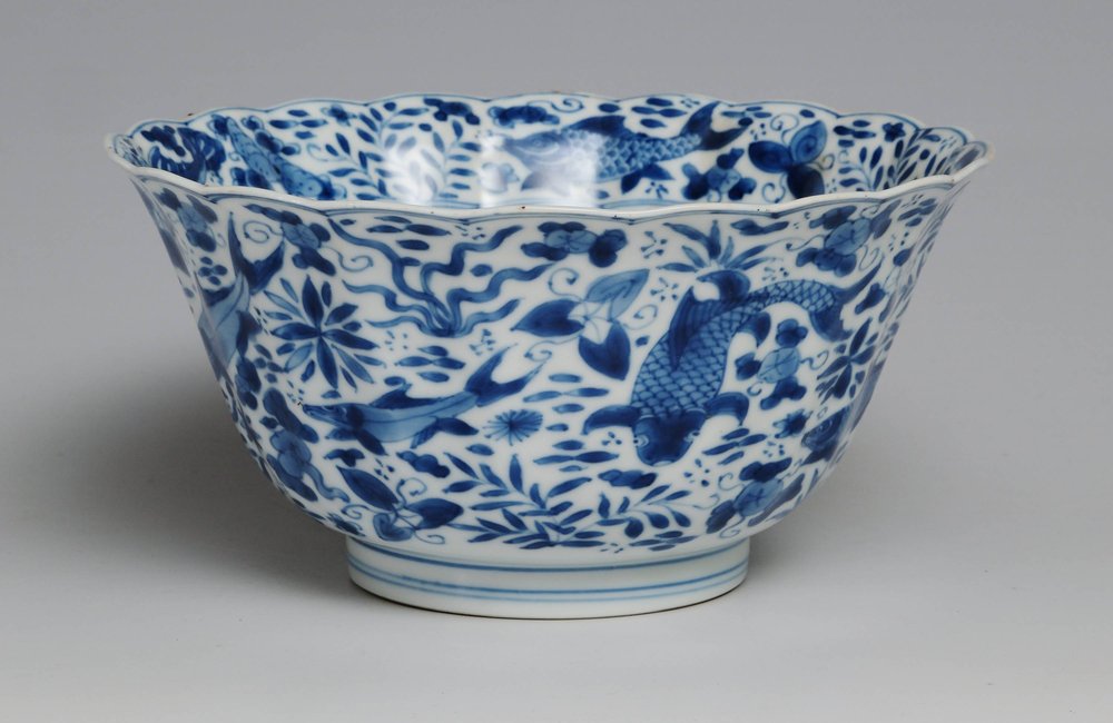 W936 Blue and white bowl, Kangxi (1662-1722), with lobed rim and molded sides, decorated with fish swimming among aquatic plants and water weeds, with a band of similar decoration to the inside rim.