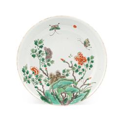A Chinese famille verte circular dish, Qing dynasty, Kangxi period, painted with butterflies and peony among garden rocks, 21cm diameter