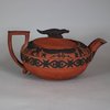 W713 A Wedgwood 'Rosso Antico' teapot, cover and stand, circa 1820 Of circular form with a crocodile finial, the borders applied with black sprigs in Egyptian style, stand 20cm diam., impressed WEDGWOOD (3