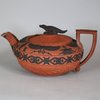 W713 A Wedgwood 'Rosso Antico' teapot, cover and stand, circa 1820 Of circular form with a crocodile finial, the borders applied with black sprigs in Egyptian style, stand 20cm diam., impressed WEDGWOOD (3