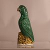 W886 A Chinese famille verte biscuit parrot,  Kangxi (1662-1722), the bird painted  with green enamel and modelled  standing on yellow rockwork,