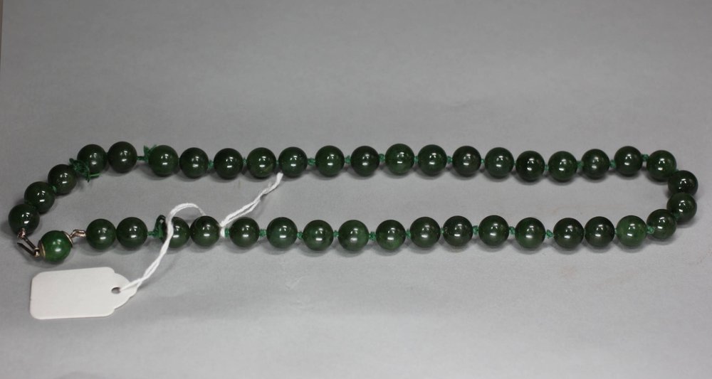 P217 Dark green jade bead necklace, length: 18 3/4in., 47.5cm. 