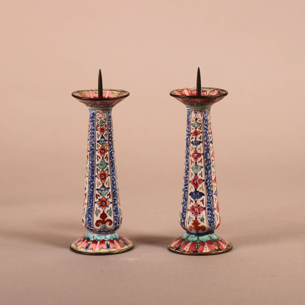 W917 A pair of Chinese Qianlong Canton enamel pricket candlesticks, the fluted tapering stems painted with panels of flowers in famille rose colours,